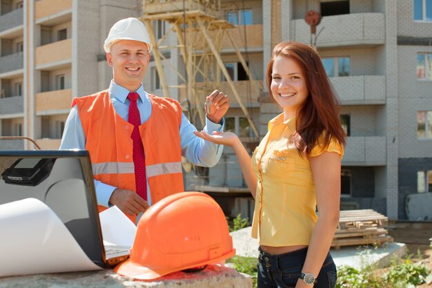 a man and woman standing outside with a laptop